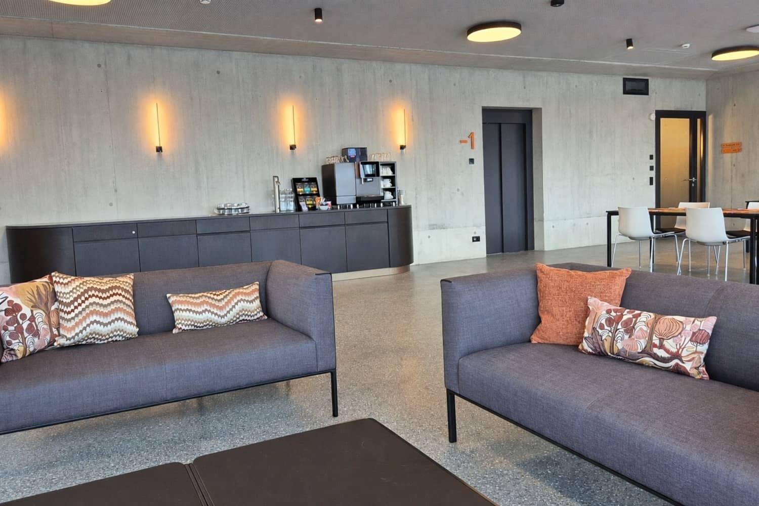 Auf zwei grauen Sofas liegen gemusterte, stilvolle Zierkissen